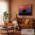 Silhueta de elefante caminhando na savana sob céu roxo e laranja do pôr do sol, quadro decorativo