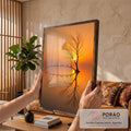 Árvore seca e aves em galho curvo refletidos no lago ao pôr do sol laranja, quadro decorativo