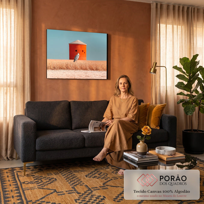 Garça cinzenta em campo de grama dourada diante de torre laranja sob céu azul, quadro decorativo