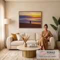 Silhueta de surfista com prancha azul na areia diante do mar ao pôr do sol laranja, quadro decorativo