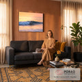 Surfista deslizando numa onda azul no mar ao pôr do sol, com céu laranja e reflexos dourados, quadro decorativo