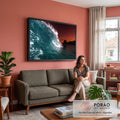 Onda do mar formando tubo azul-turquesa com céu laranja e prédios na orla ao entardecer, quadro decorativo