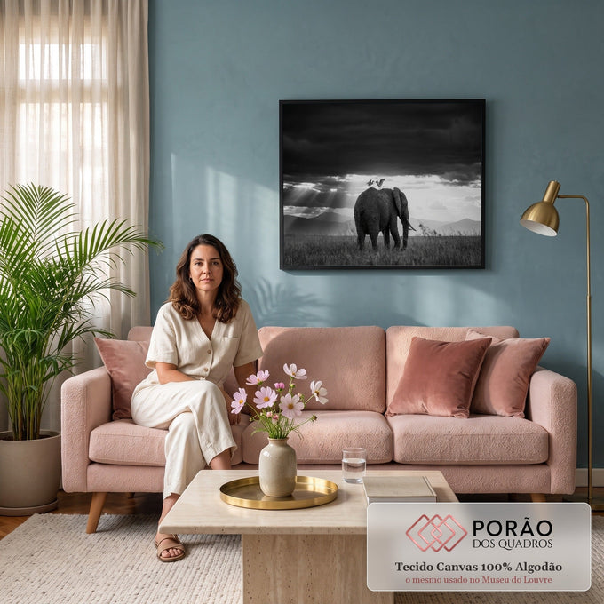Elefante com duas garças nas costas sob céu escuro e raios de luz na savana, quadro decorativo