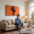 Mulher negra de perfil com turbante azul e vermelho e brinco dourado, fundo laranja, quadro decorativo