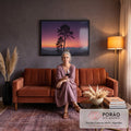 Pinheiros em silhueta sob céu roxo e laranja ao pôr do sol e montanhas enevoadas, quadro decorativo