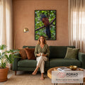 Pássaro de cabeça preta, olho vermelho e corpo castanho pousado em galho na mata verde, quadro decorativo