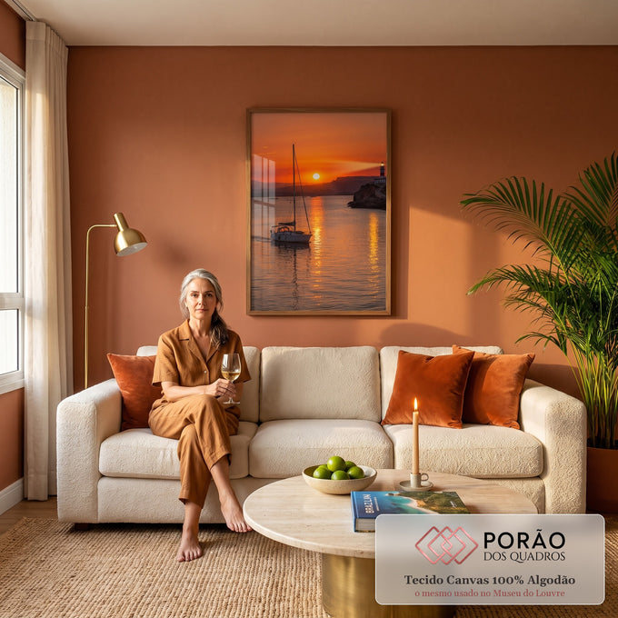 Veleiro navegando no mar laranja ao pôr do sol com farol aceso no penhasco, quadro decorativo