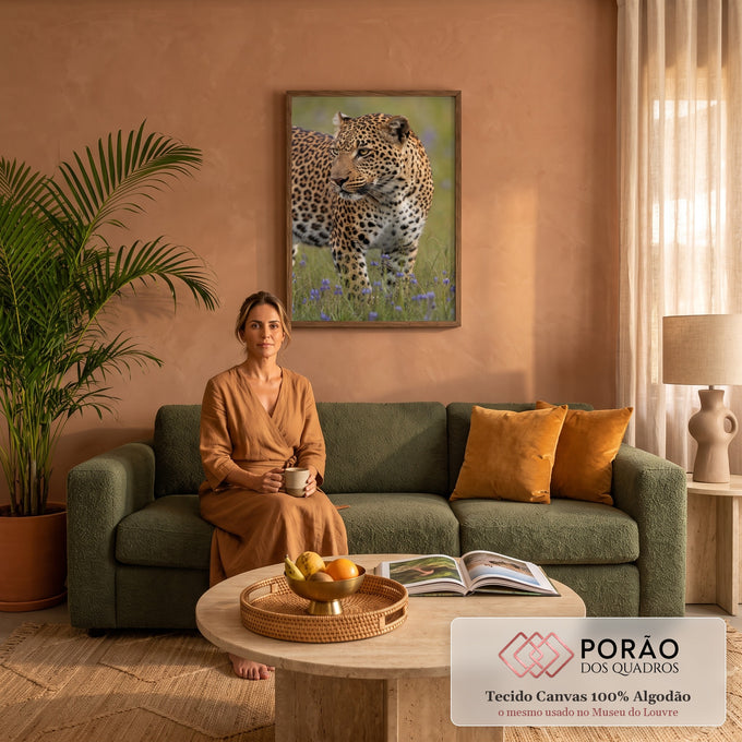 Leopardo em close olhando de lado, entre flores roxas em campo verde, quadro decorativo