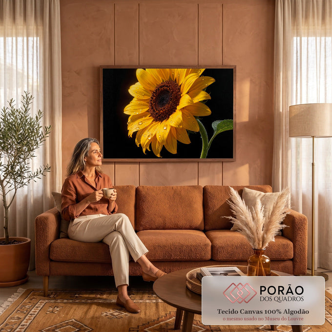 Girassol amarelo em close com gotas de água nas pétalas e folha verde sobre fundo preto, quadro decorativo