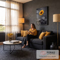 Girassol amarelo brotando entre pedras vulcânicas pretas em fundo cinza escuro, quadro decorativo