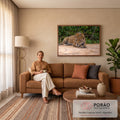 Quadro Decorativo Grande Onça Pintada para Sala Dourado | quadros decorativos para sala de estar | onça-pintada deitada na areia com olhar fixo e fundo de folhagem verde | em ambiente 3 | Porao dos Quadros