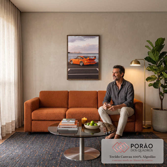 Porsche 911 laranja com aerofólio e rodas raiadas à beira-mar, skyline ao fundo, quadro decorativo