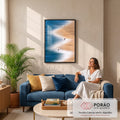 Praia vista do alto com mar azul, espuma branca em zigue-zague e pessoas na areia, quadro decorativo
