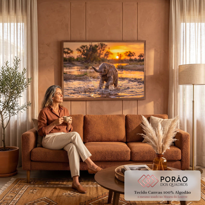 Filhote de elefante espirrando água com a tromba em rio da savana ao pôr do sol, quadro decorativo