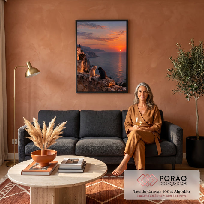 Gato branco e gato preto em muro de pedra olhando o pôr do sol laranja sobre o mar, quadro decorativo