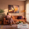 Quadro Decorativo Grande Mulher ao Pôr do Sol para Sala | quadros decorativos para sala de estar | mulher sentada na proa de veleiro observando pôr do sol laranja e roxo sobre o mar | em ambiente 3 | Porao dos Quadros