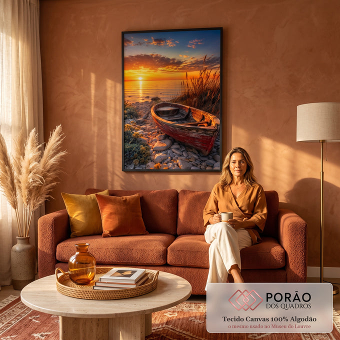 Barco de madeira vermelho em praia de pedras com capim e pôr do sol laranja sobre o mar, quadro decorativo