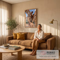 Quadro Decorativo Grande Família de Girafas Marrom para Sala | quadros decorativos para sala de estar | filhote de girafa entre dois adultos formando arco de pescoços sob céu azul | em ambiente 3 | Porao dos Quadros