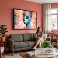Rosto de mulher azul com lábios laranja e veleiro no olho sobre pinceladas coral, quadro decorativo