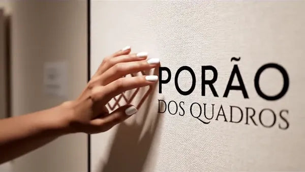 Close do tecido canvas branco com o logo do Porão dos Quadros e a moldura de um quadro